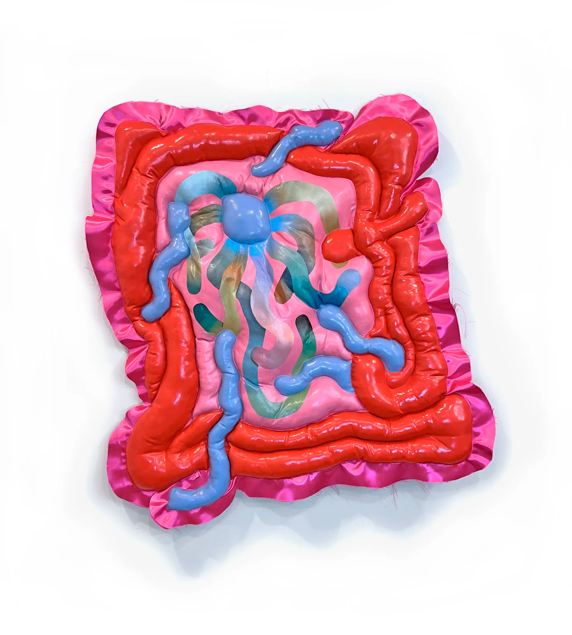 Pink and red layered fabric relief sculpture with blue squiggly elements and painted center