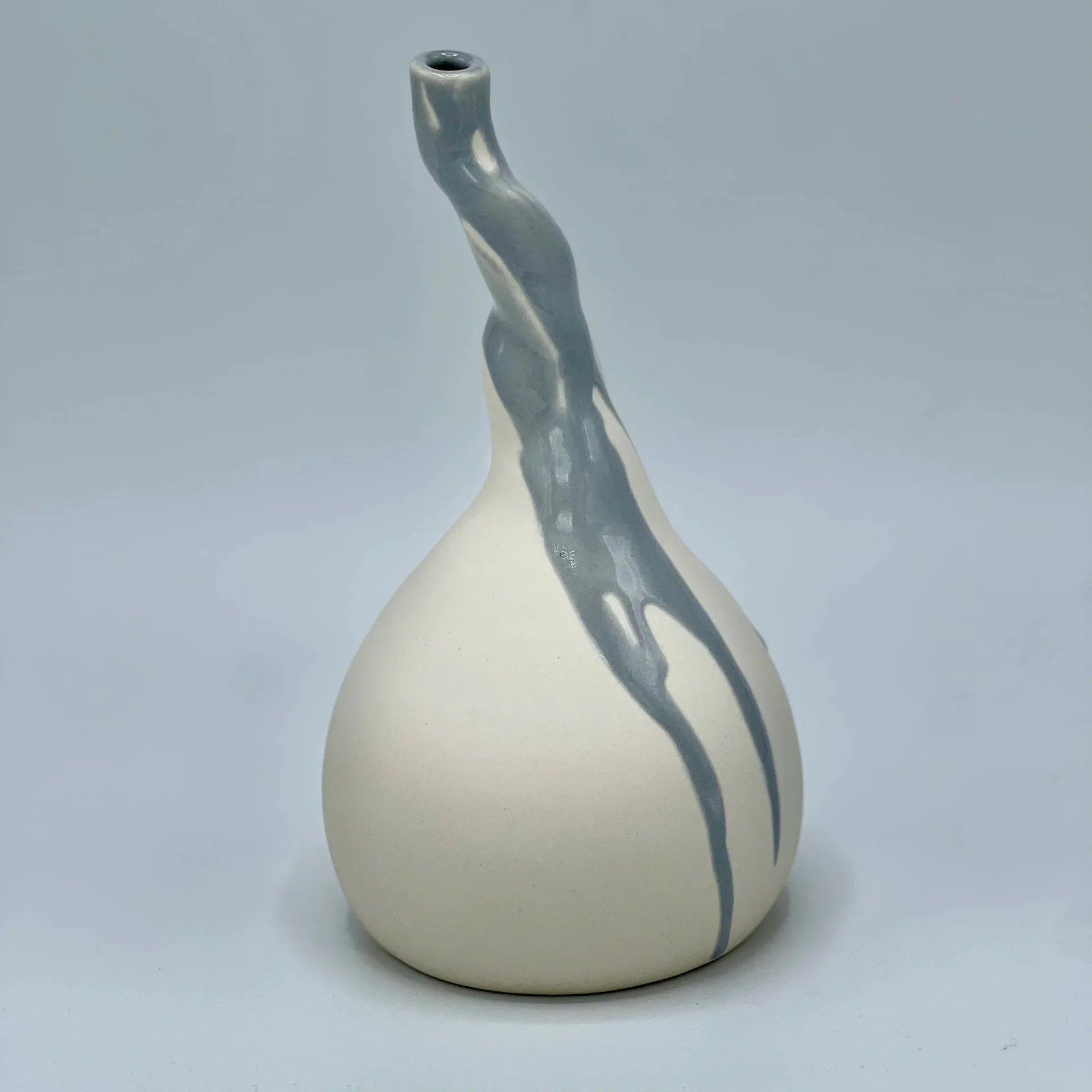 White ceramic vase with asymmetric curved neck and grey glaze drip detail