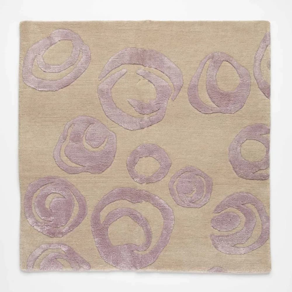Tufted rug with large swirling rose motifs in lavender on beige ground