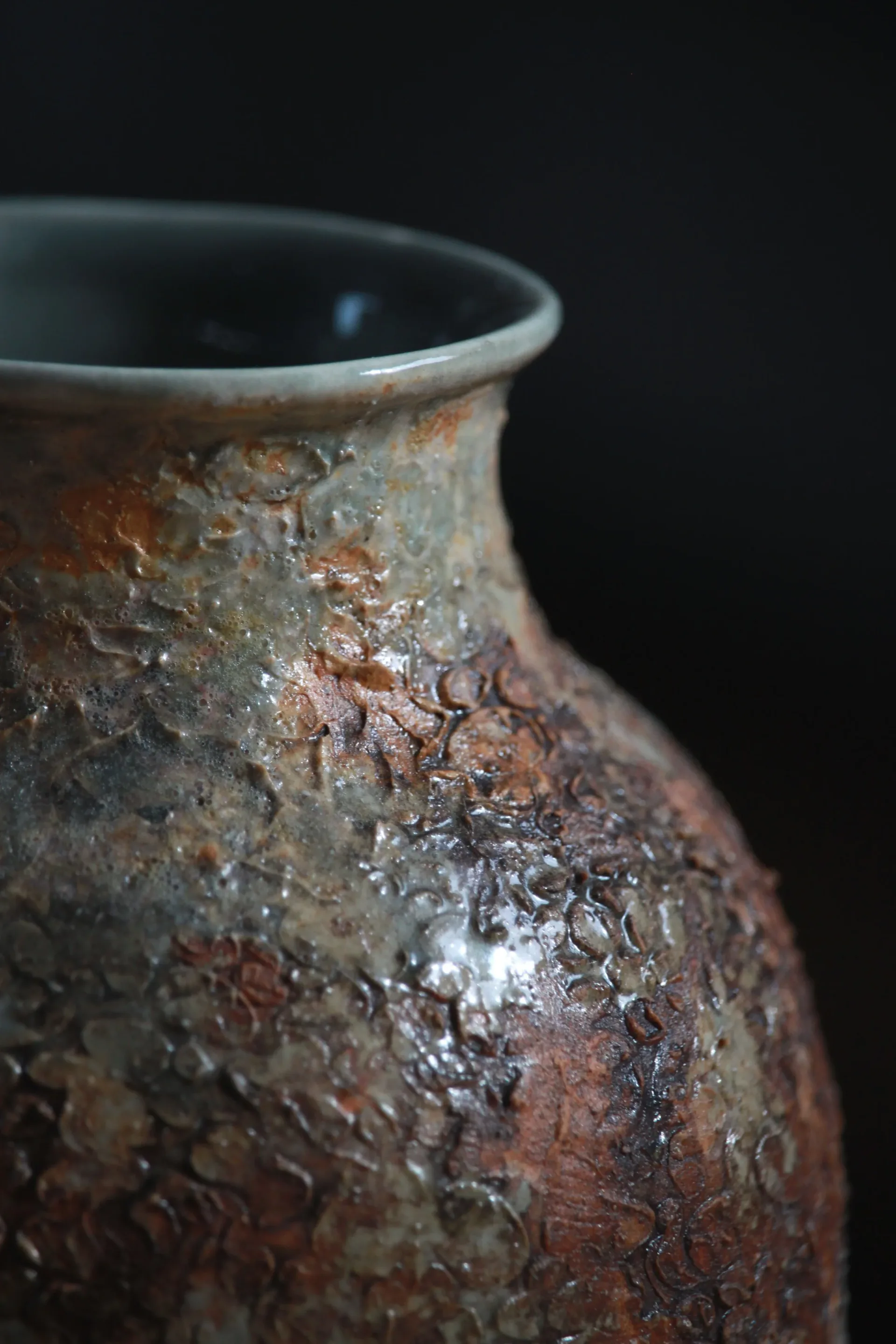 Large ceramic vase with richly textured volcanic glaze in earthy rust and green tones
