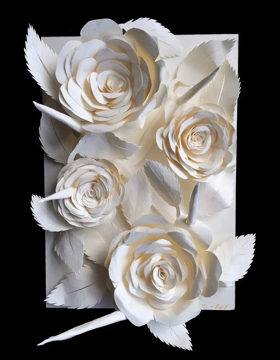 White paper roses sculpture with feathered leaves on black background