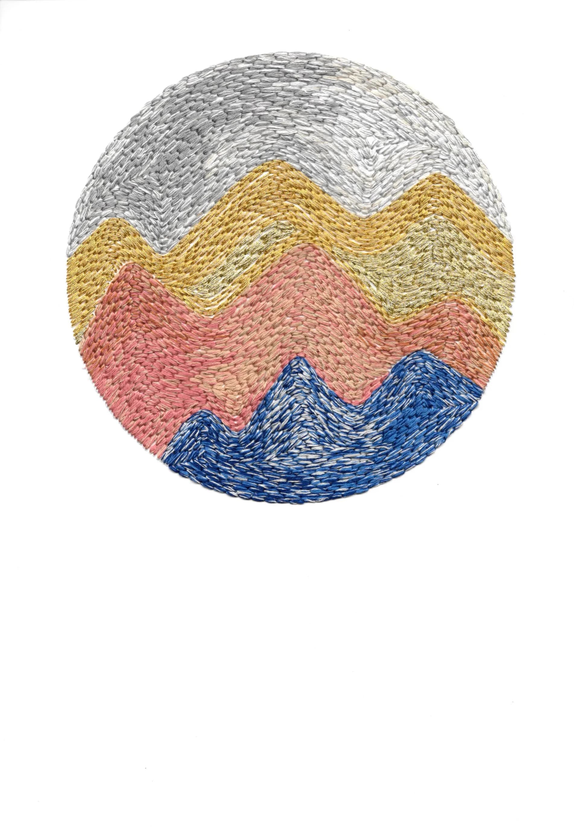 Circular embroidery with layered mountain-like forms in silver, gold, pink, and blue thread