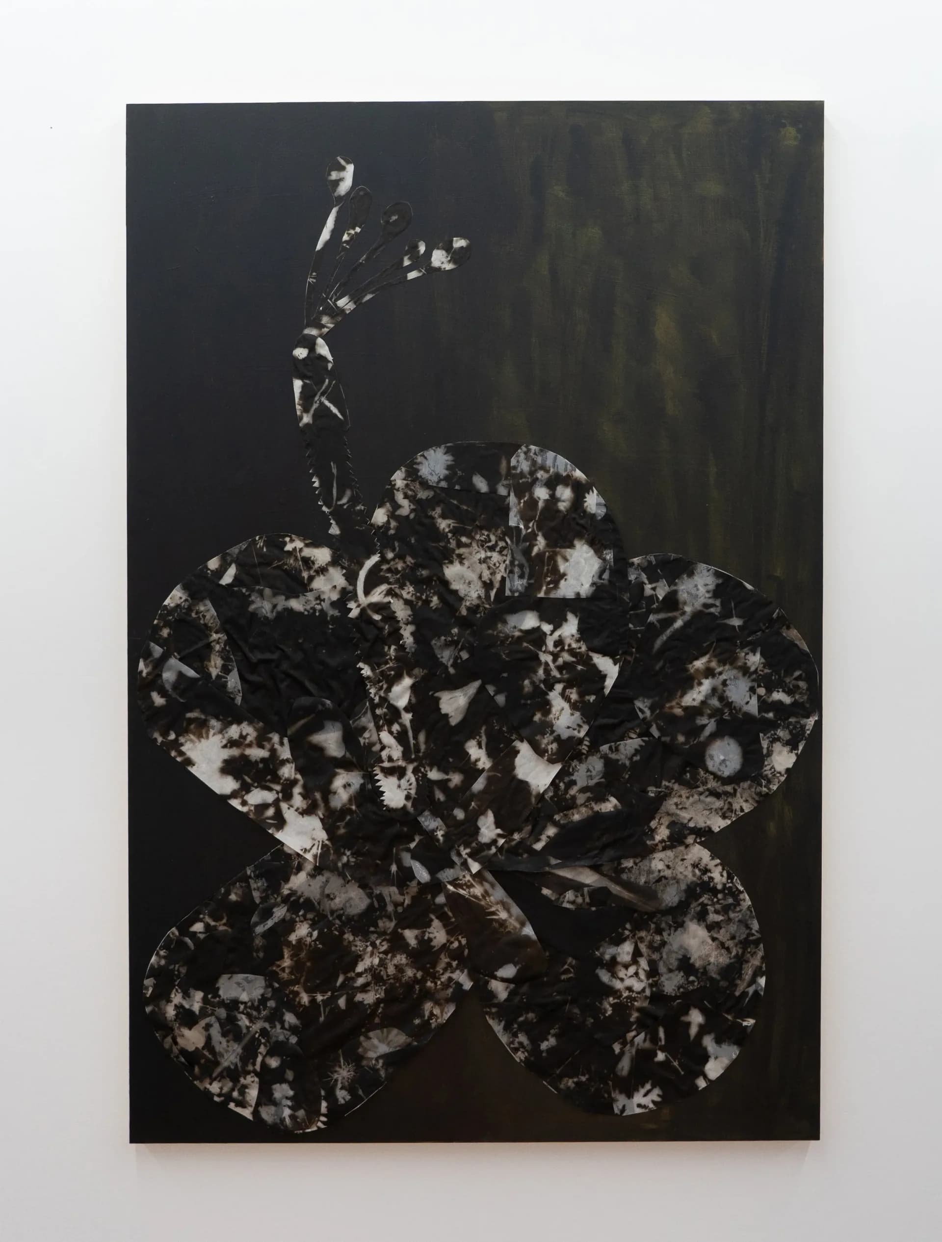 Large dark canvas with flower silhouette composed of photographic fragments on painted black and green ground