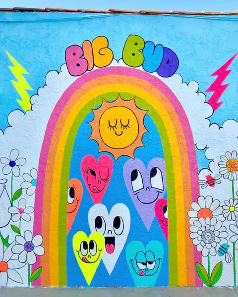 Big Bud mural featuring a rainbow arch, smiling sun, and playful heart characters with flowers and lightning bolts