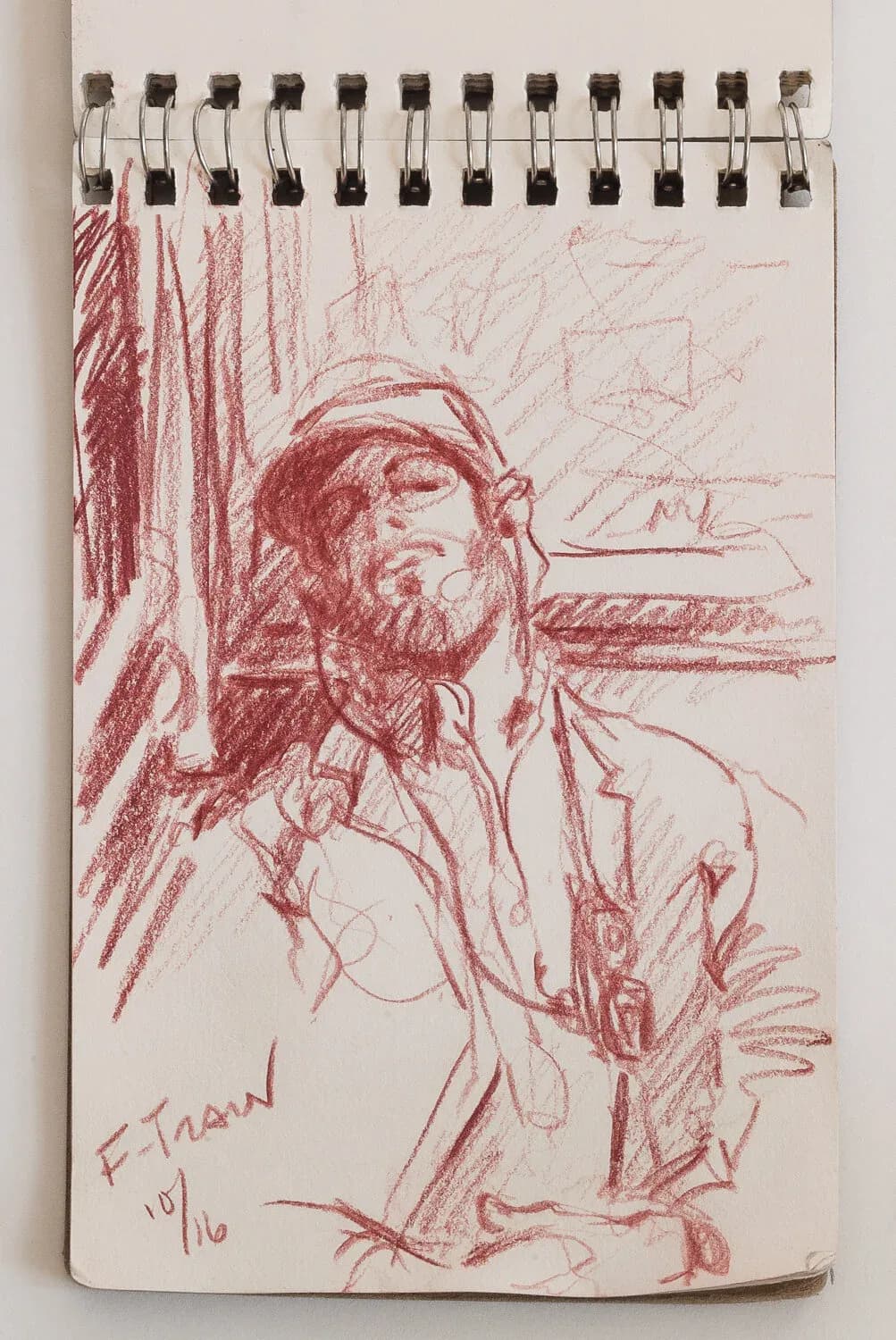 Red conte crayon sketch of a bearded man with headphones on the F Train, dated 10/16