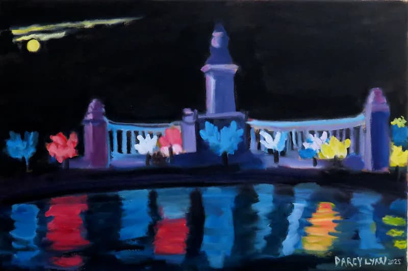 Night scene of Retiro Park monument with colorful illuminated trees reflecting in water