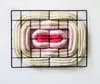 Pink and white fabric textile sculpture with concentric forms on metal grid frame