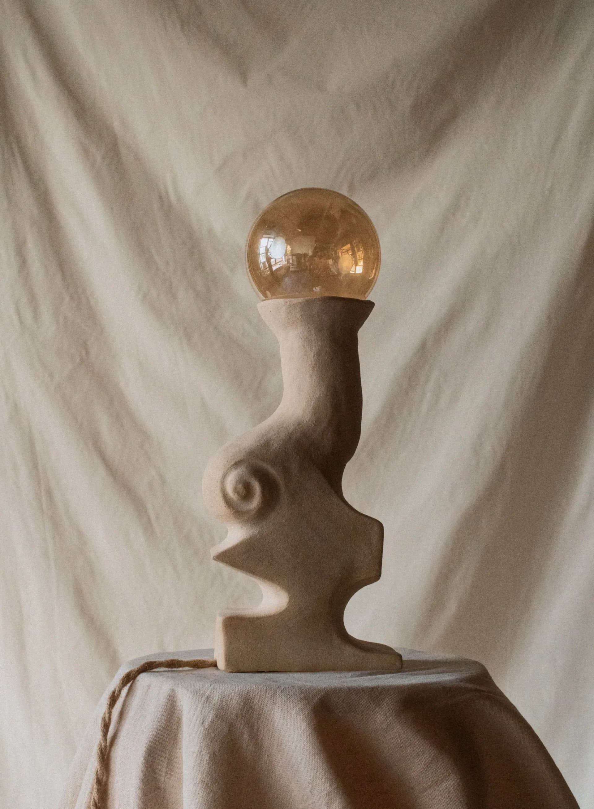Sculptural ceramic lamp with abstract female torso form and amber glass globe