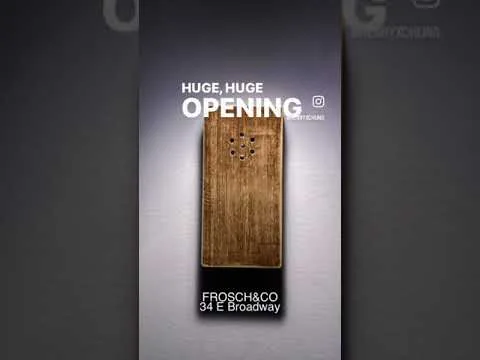 Vertical promotional graphic with large white text reading 'HUGE, HUGE OPENING' and 'FROSCHI&CO 34 E Broadway' centered above a wood-textured rectangular image against a gradient gray background.