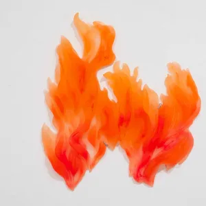 Close-up of two orange and red flame sculptures mounted on white wall