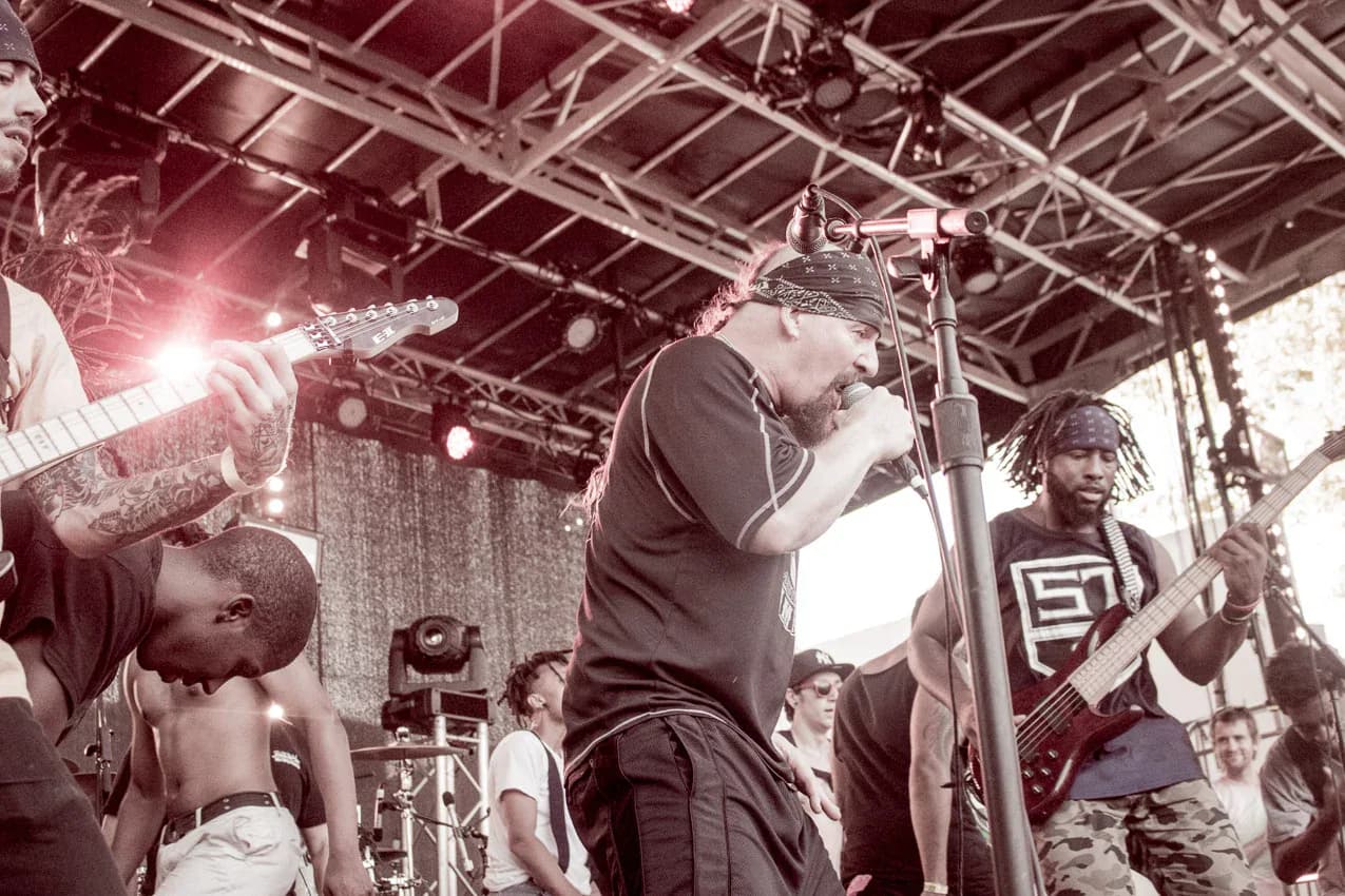 Guitarist performing on stage at Afropunk festival with crowd behind
