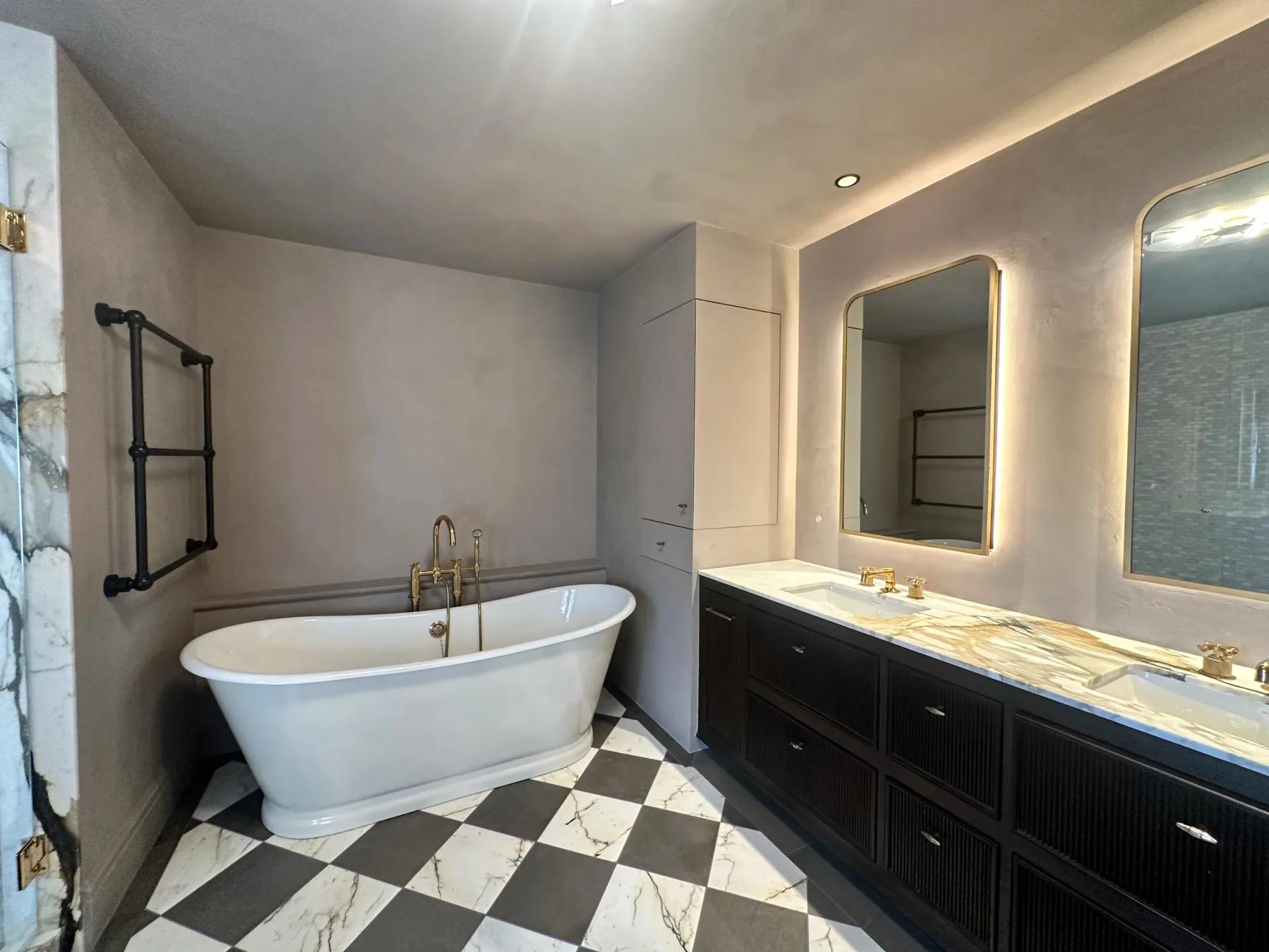 Luxury bathroom with warm grey venetian plaster walls, freestanding tub, and checkerboard marble floor
