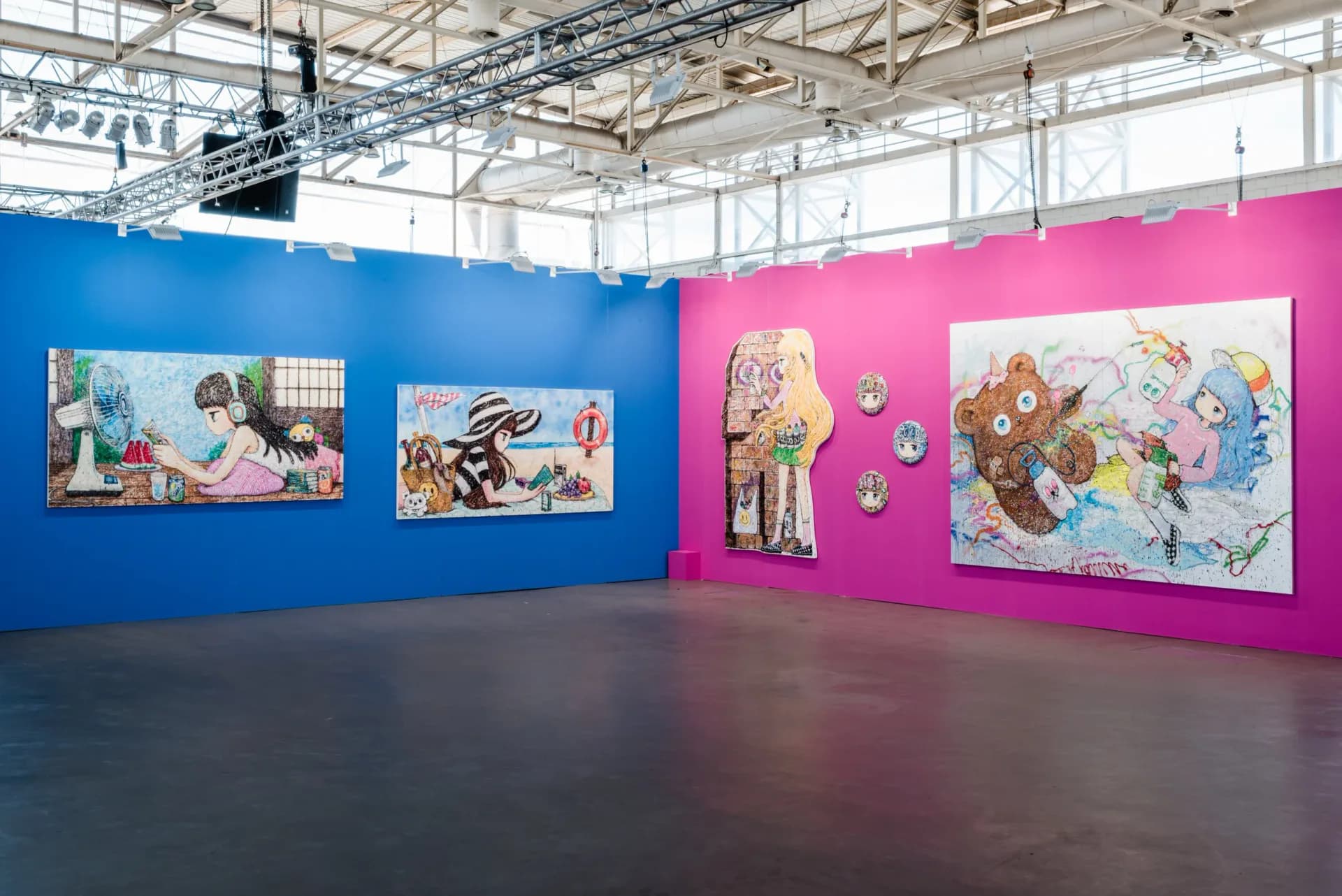 Gallery installation view with colorful large-scale paintings of anime-style girls on blue and pink walls at Can Art Fair Ibiza 2022