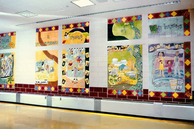 Large-scale mixed-media mural installation with colorful geometric borders and collaged illustrations featuring children, nature, and community scenes in yellow, blue, and red tones.