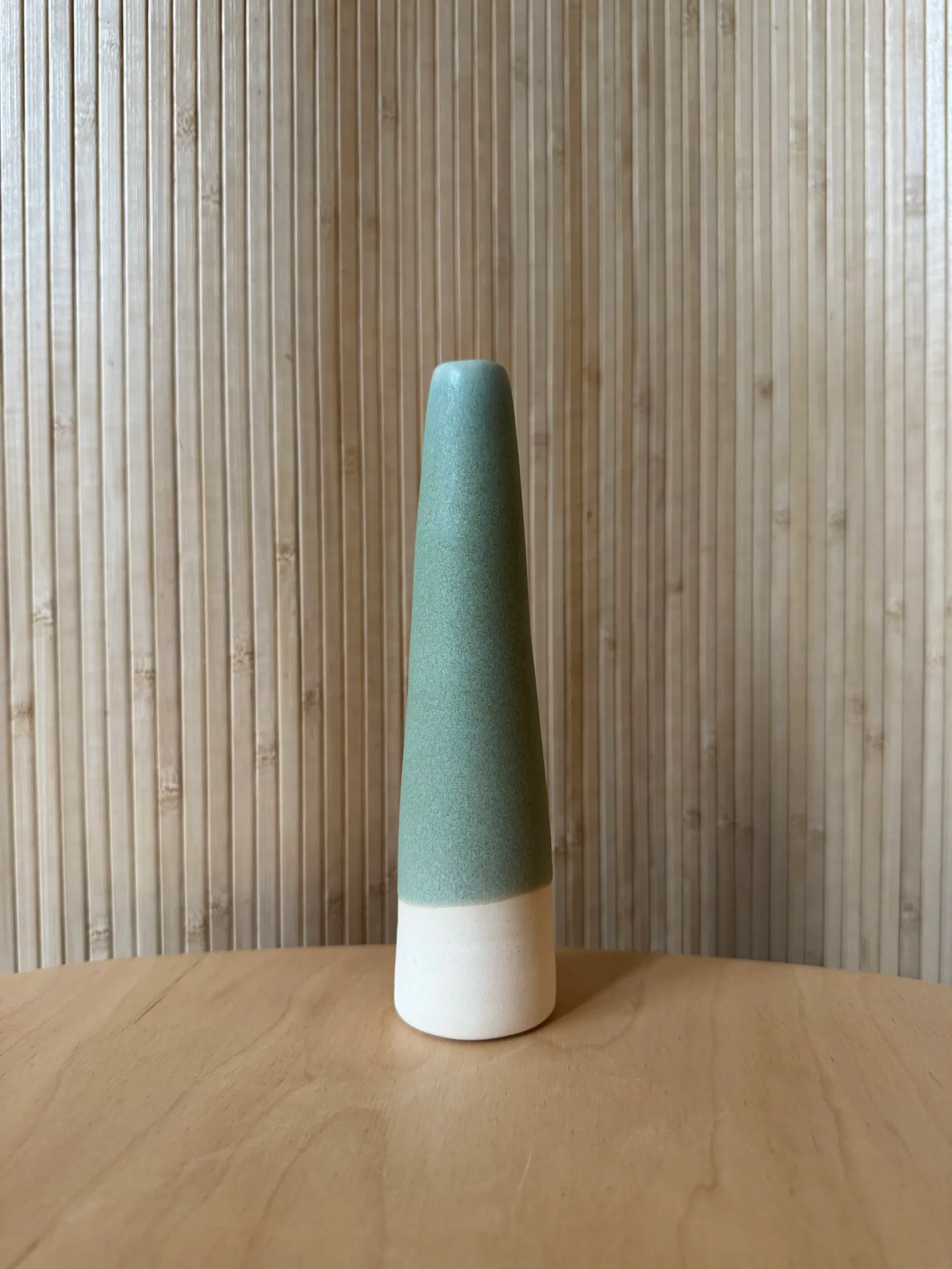 Honey-brown ribbed ceramic vessel with ruffled wavy rim, alone on white shelf