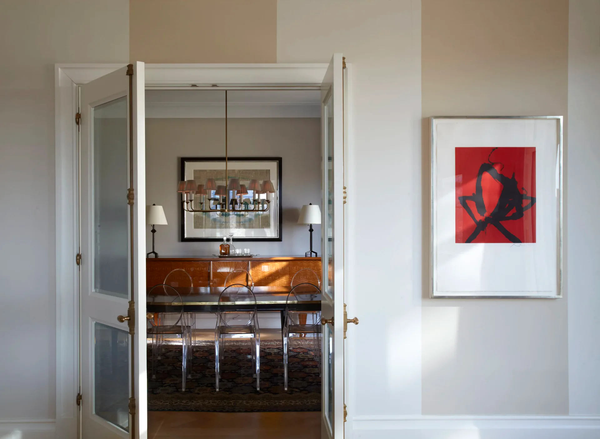 Dramatic black and white dining room with floral curtains and crystal chandelier