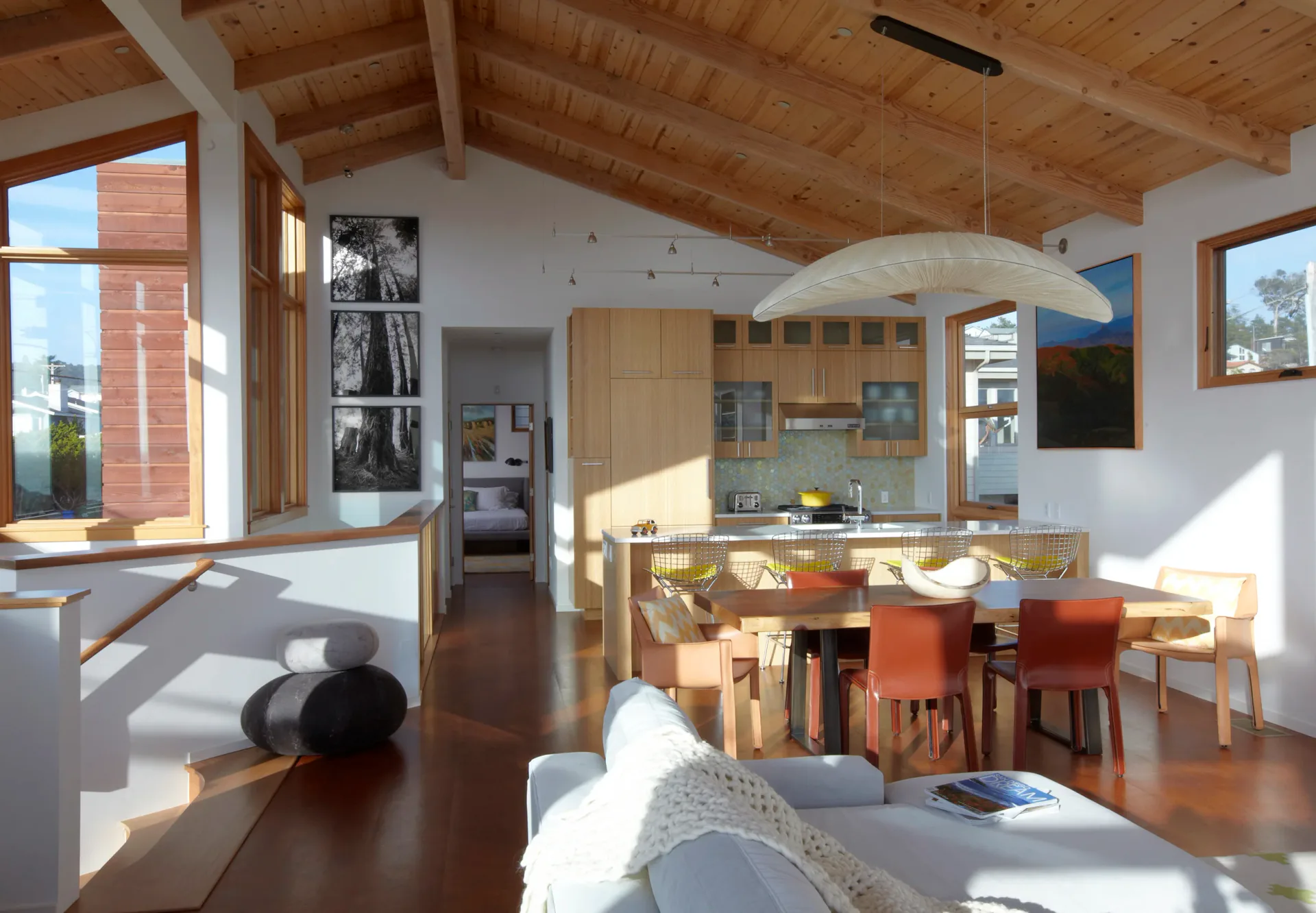 Bright open-plan living and kitchen area with wood-beam ceiling and natural light