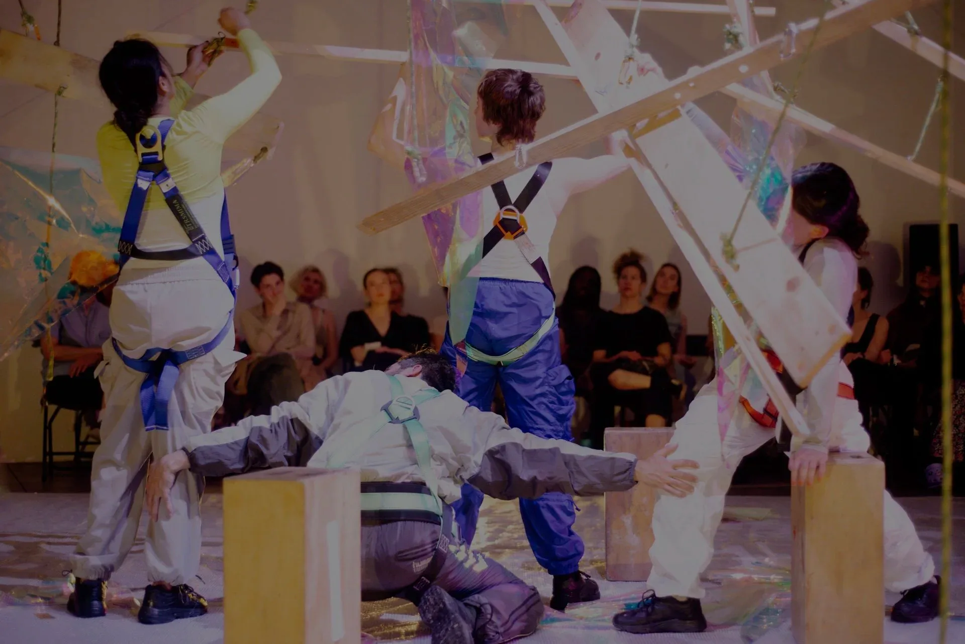 Two dancers in red shirts performing in warm-lit brick-walled space