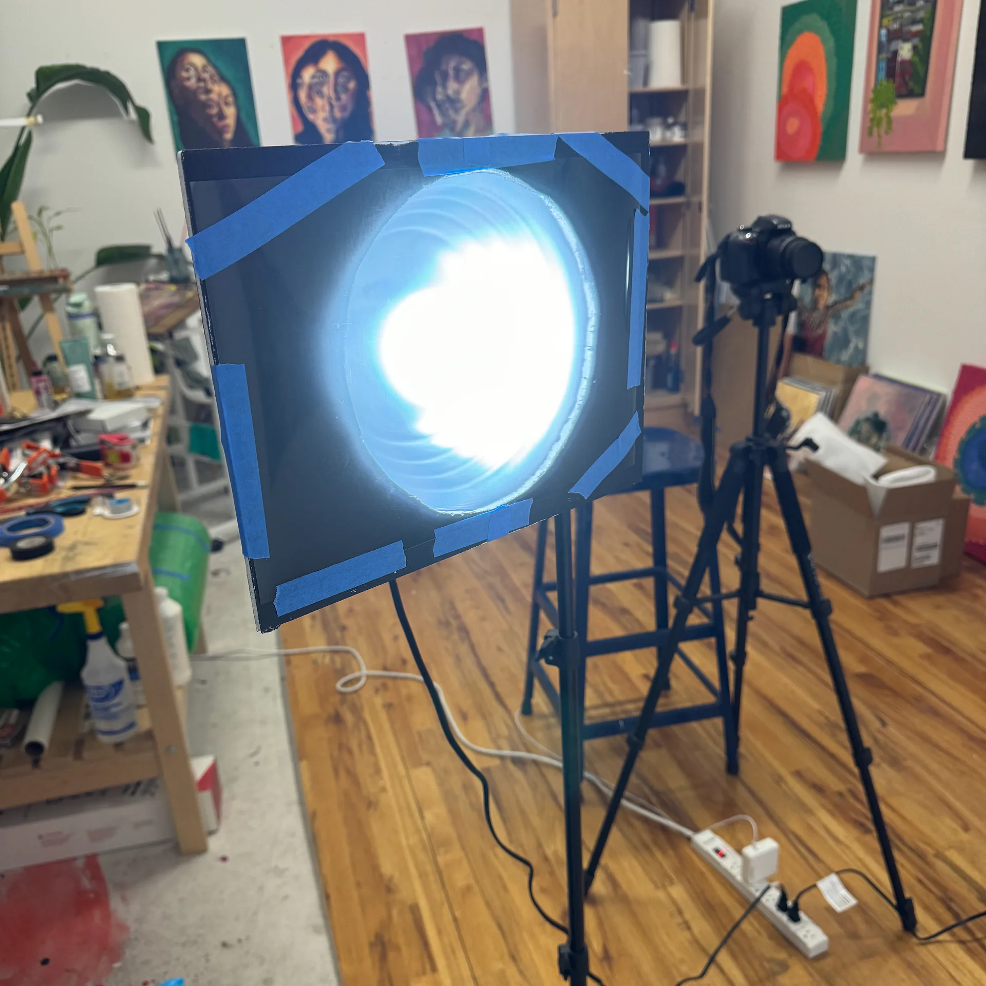 Finished oil painting of multiple overlapping faces with glasses on teal background