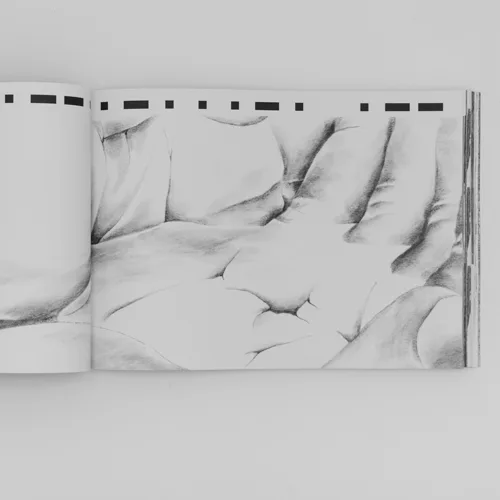 Open artist book spread showing detailed pencil drawing of a hand