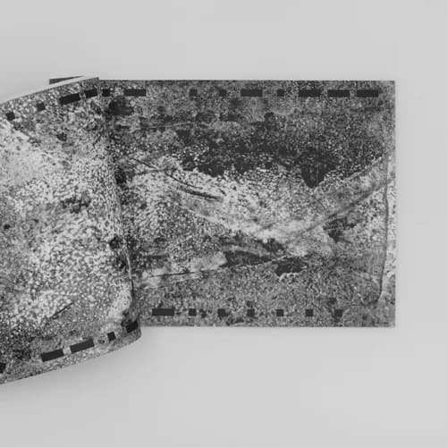 Book spread showing abstract darkroom/film texture imagery