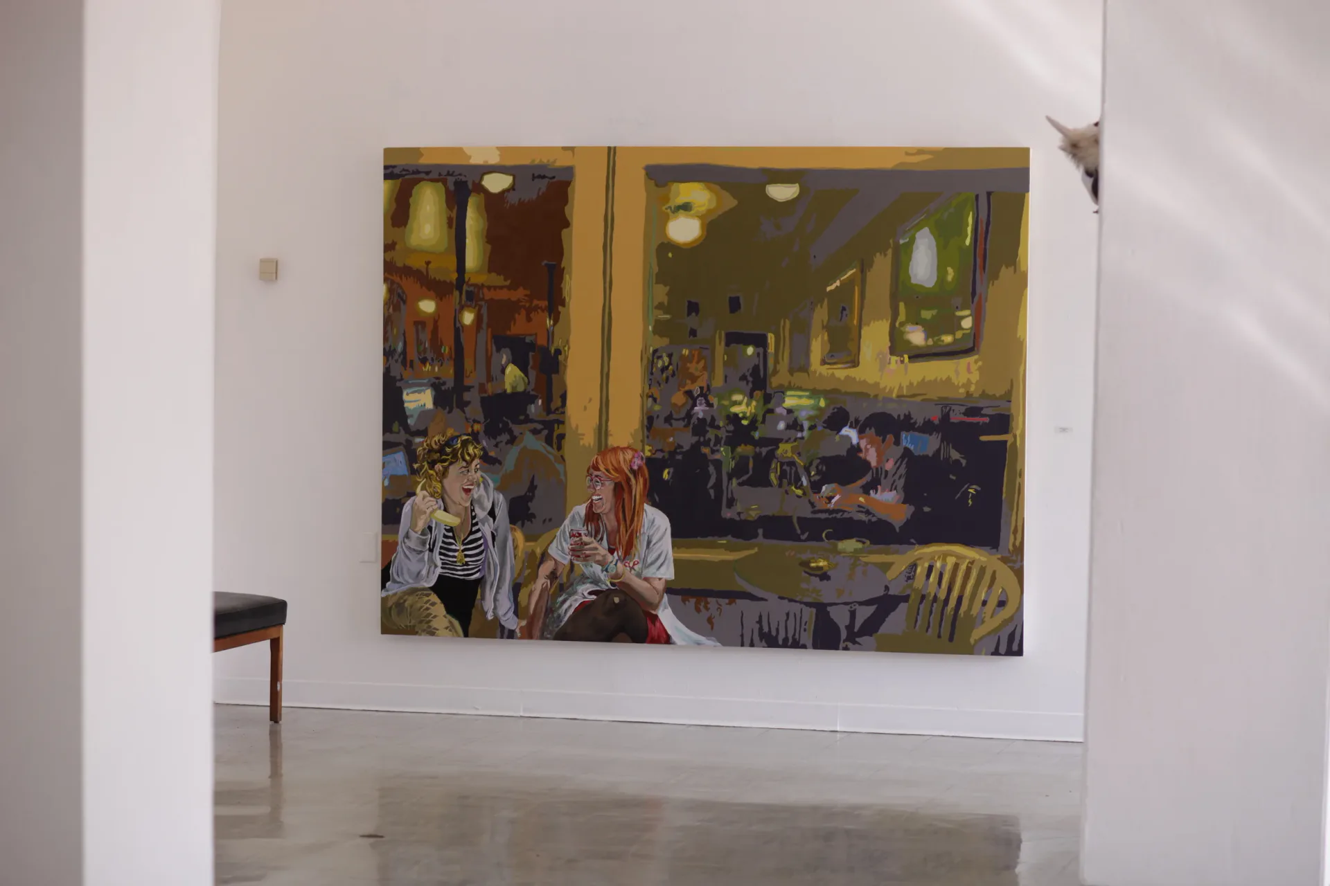Large-scale stencil painting of people in a cafe with flattened color fields in golden tones