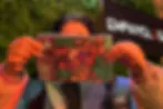 Heavily blurred image with orange and red tones; subject indiscernible due to motion or extreme pixelation.