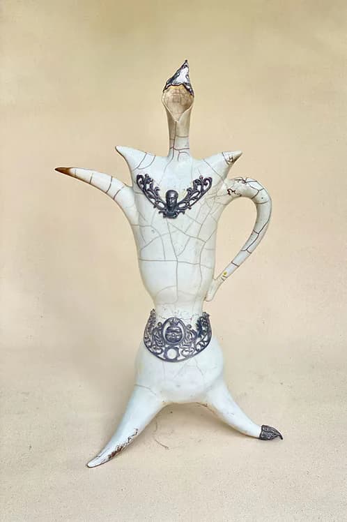 White raku ceramic teapot sculpture with crackle glaze, metal ornaments, and figural legs