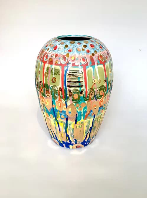 Ceramic vessel with rounded ovoid shape, hand-painted with vibrant multicolored figures, text, and geometric patterns in blue, red, yellow, and green across entire surface.