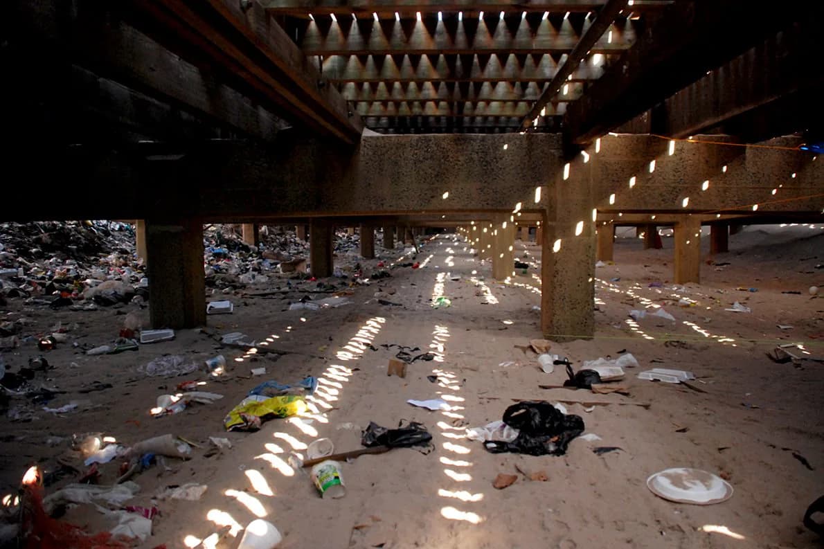 Abandoned building interior flooded with light at the end of a dark industrial corridor
