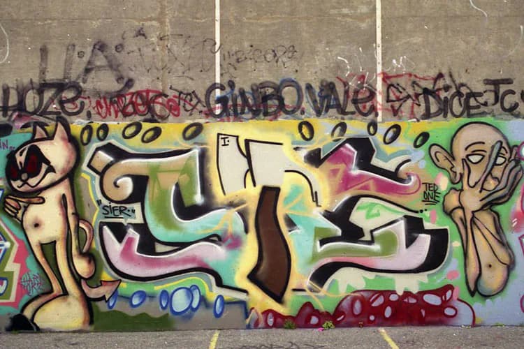 Colorful graffiti mural by SIE HR featuring abstract organic shapes in yellow, green, pink, and black with stylized figures and flowing letterforms.