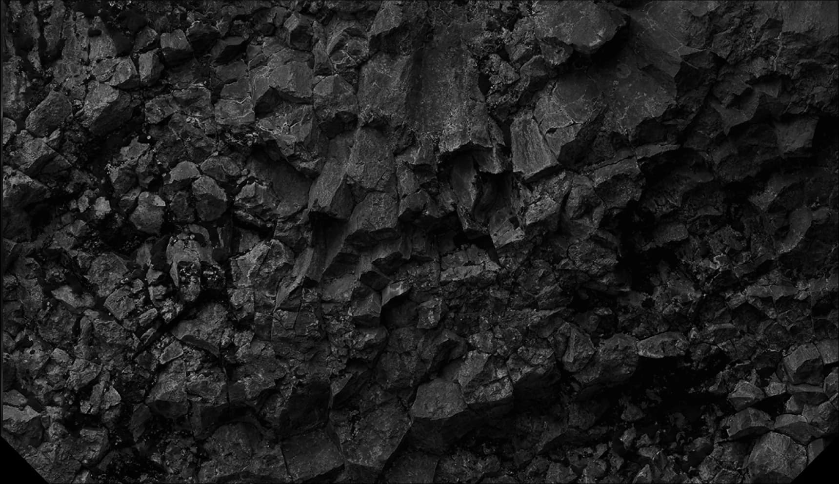 Close-up black and white photograph of fractured dark basalt rock formations