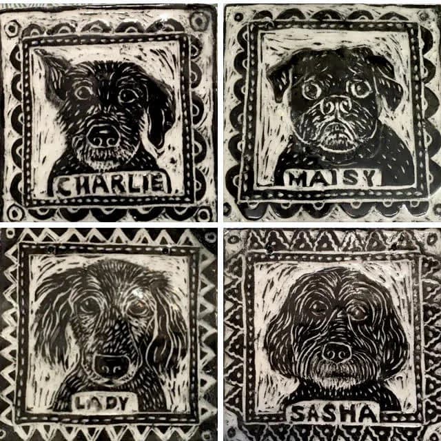 Four black and white ceramic dog portrait tiles showing Charlie, Maisy, Lady, and Sasha