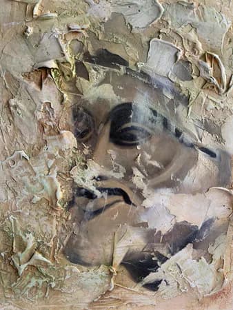Heavily textured plaster relief portrait with classical features and expressive line work, mounted on layered surface.