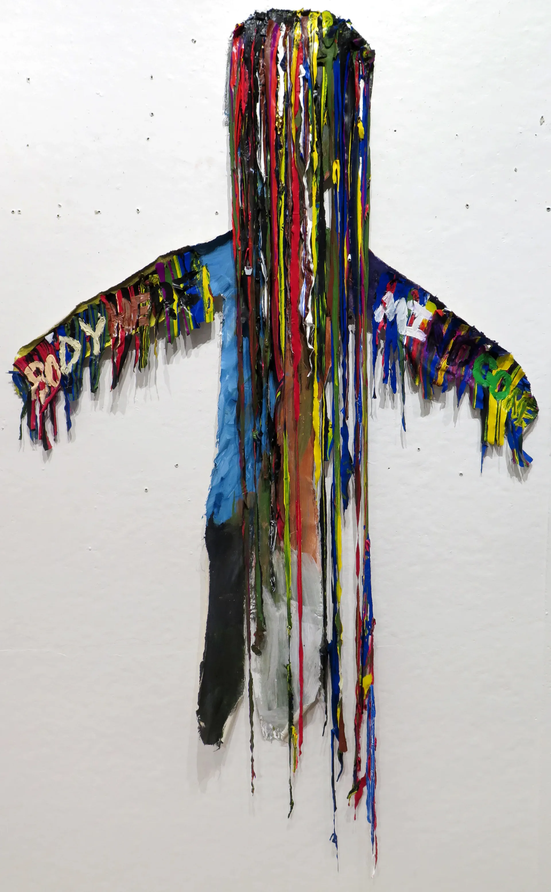 Human figure-shaped mixed media wall sculpture with cascading multicolor paint drips
