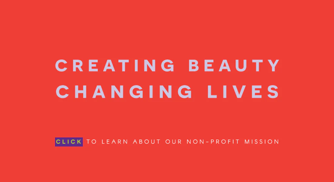 Vibrant red promotional graphic with white sans-serif text reading 'CREATING BEAUTY CHANGING LIVES' and a blue clickable button about a non-profit mission.