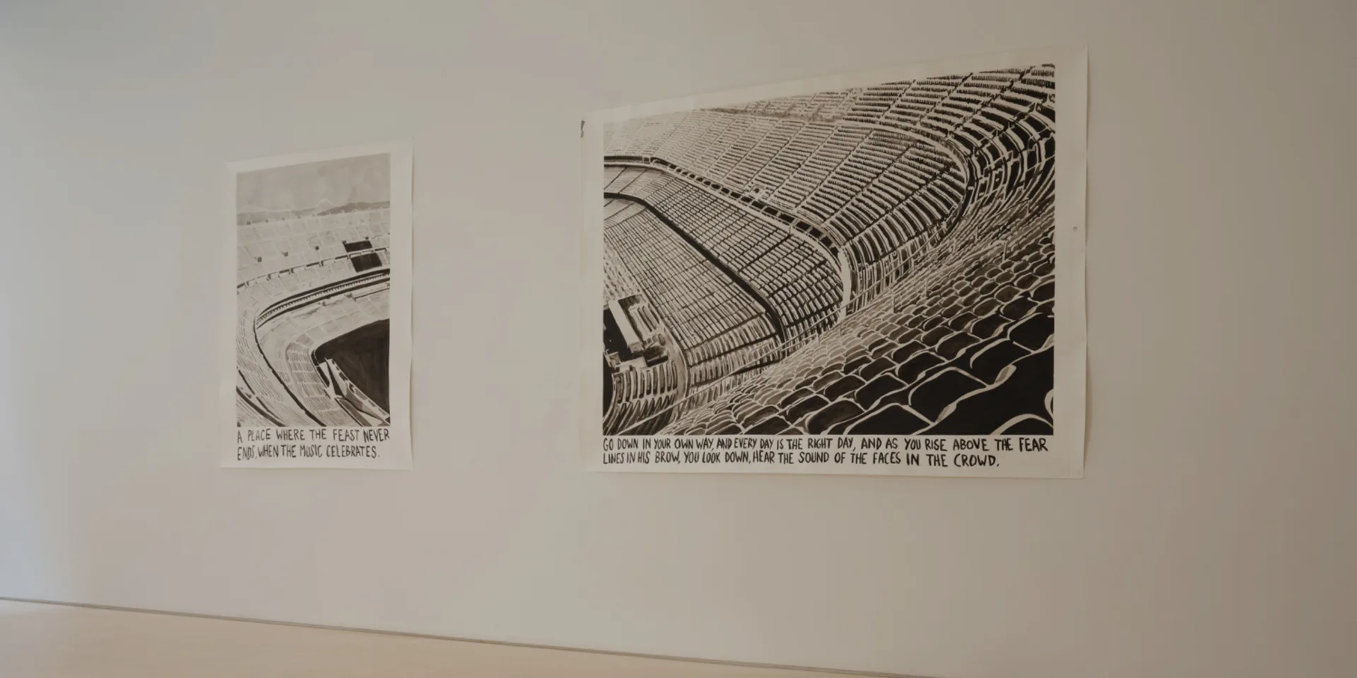 White gallery wall displaying two black-and-white architectural photographs: a small drawing and larger structural detail image.