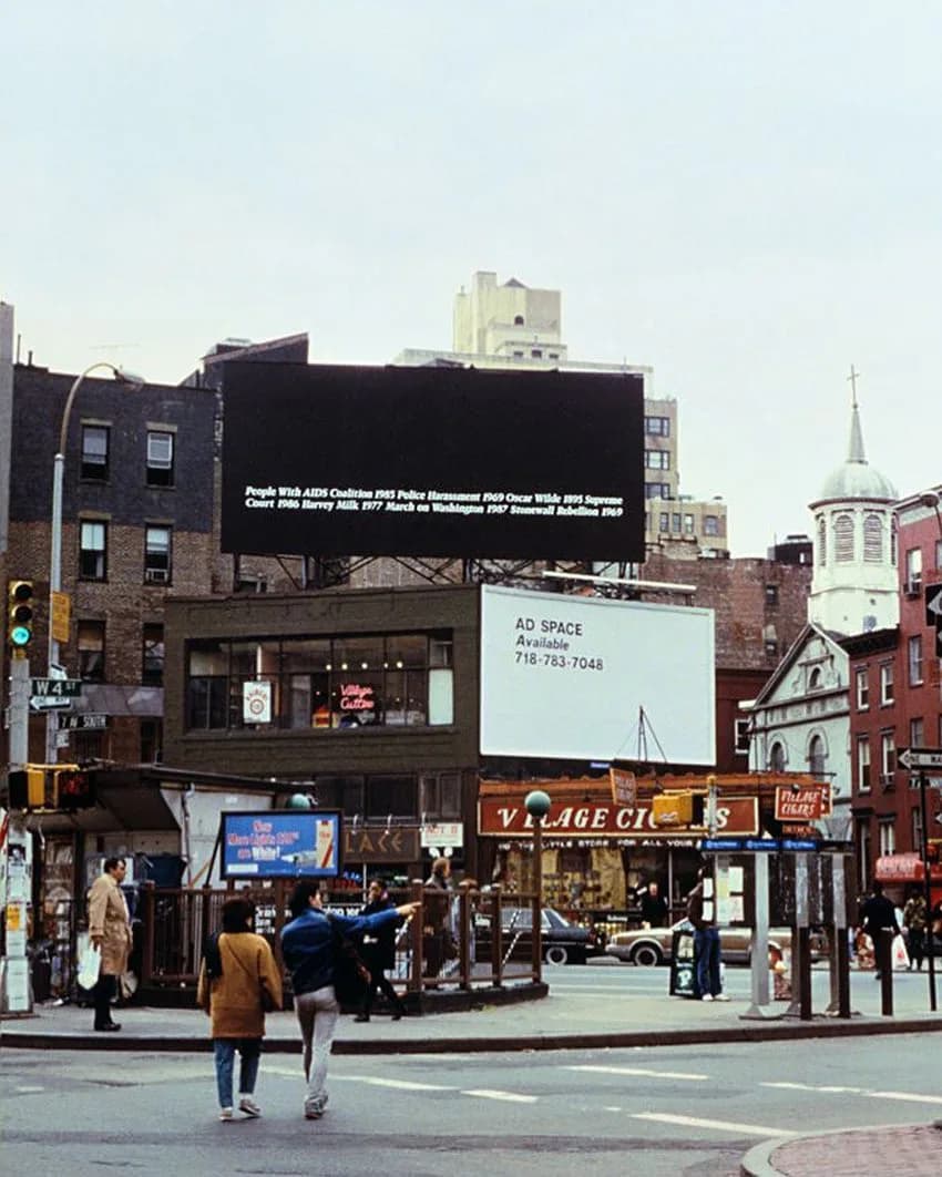 Urban street view of gallery storefront with black marquee signage, white "AD SPACE" sign, and surrounding buildings; busy pedestrian area.