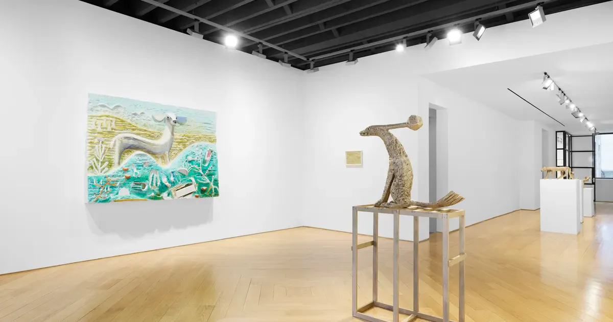 Minimalist gallery interior at Anton Kern Gallery with light wood floors, white walls, a colorful abstract painting on the left, and a sculptural bronze figure on a pedestal.
