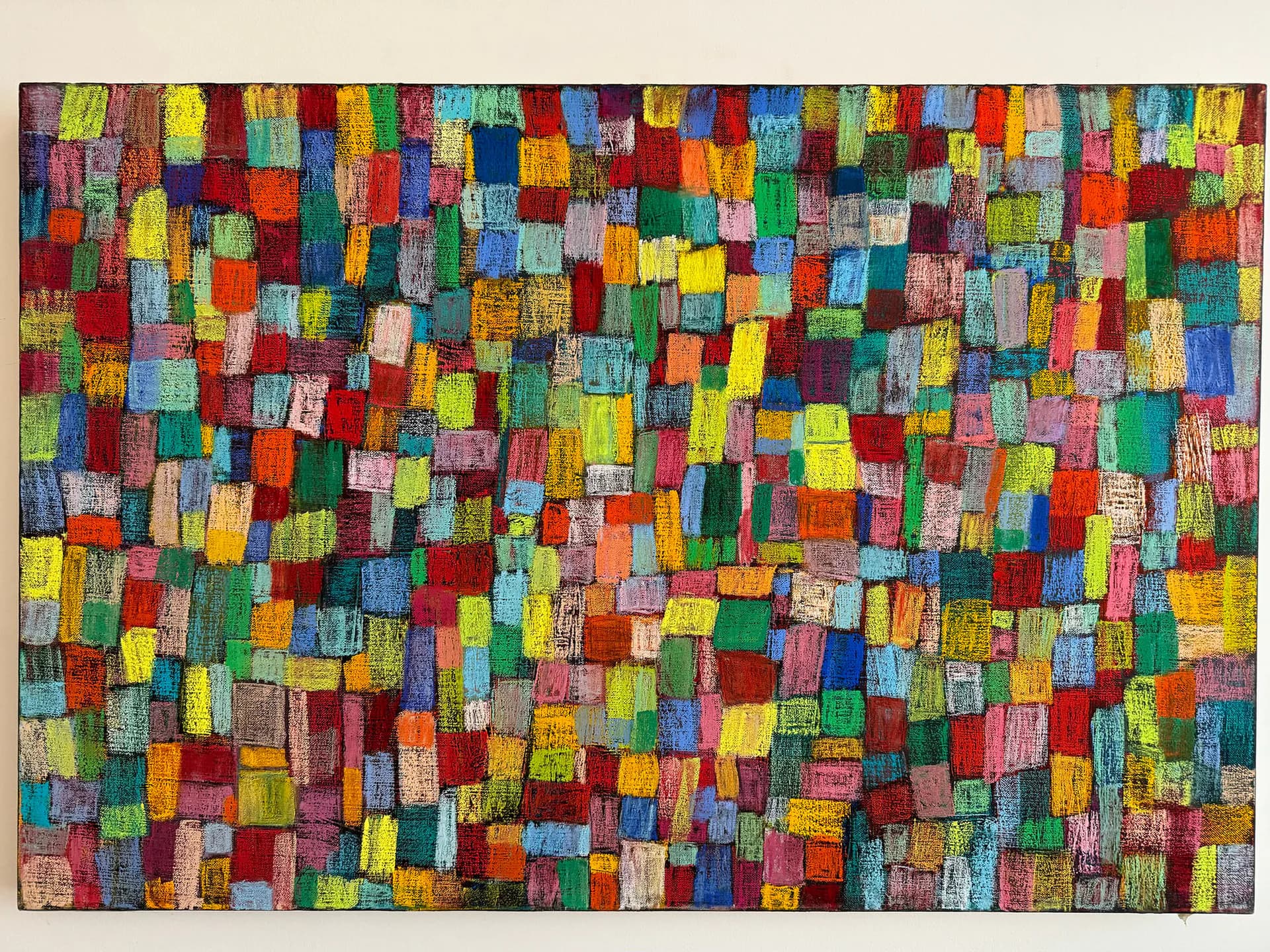 Abstract composition of hundreds of small colorful rectangular blocks in varied hues—red, yellow, blue, green, pink—densely arranged across the entire canvas.