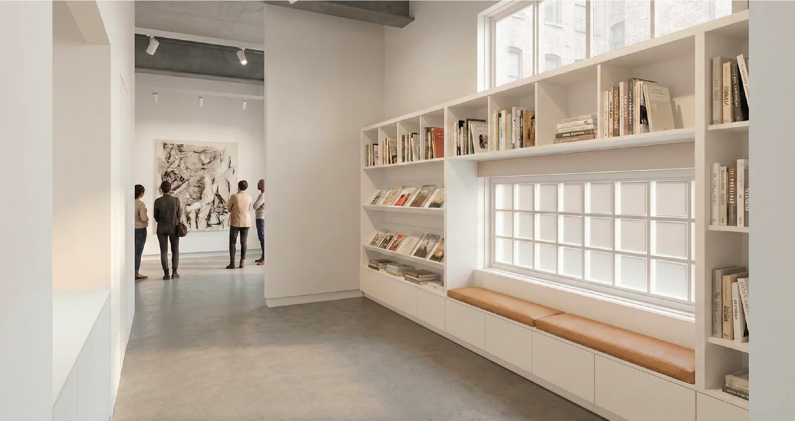 Bright gallery interior with wooden built-in shelving displaying books, a window with grid panes, and visitors viewing artwork on white walls.