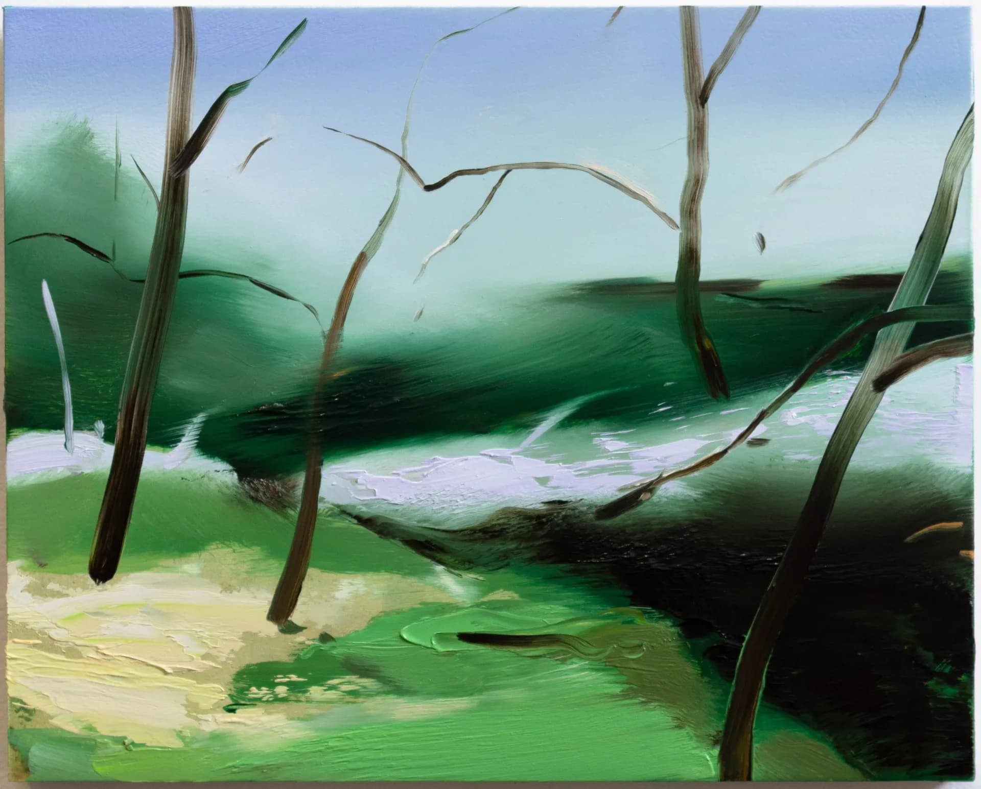 Landscape painting featuring bare trees with dark trunks against rolling green hills, soft blue sky, and a pale river or stream flowing through the center.
