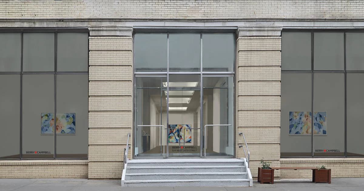 Exterior storefront of Berry Campbell gallery in Manhattan, featuring large glass windows with geometric frames, cream-colored brick facade, and a white entrance platform.