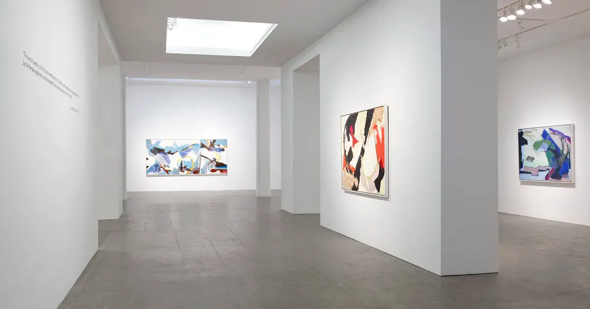 Interior view of Berry Campbell gallery white-walled exhibition space with skylights, displaying abstract and colorful artworks on walls.