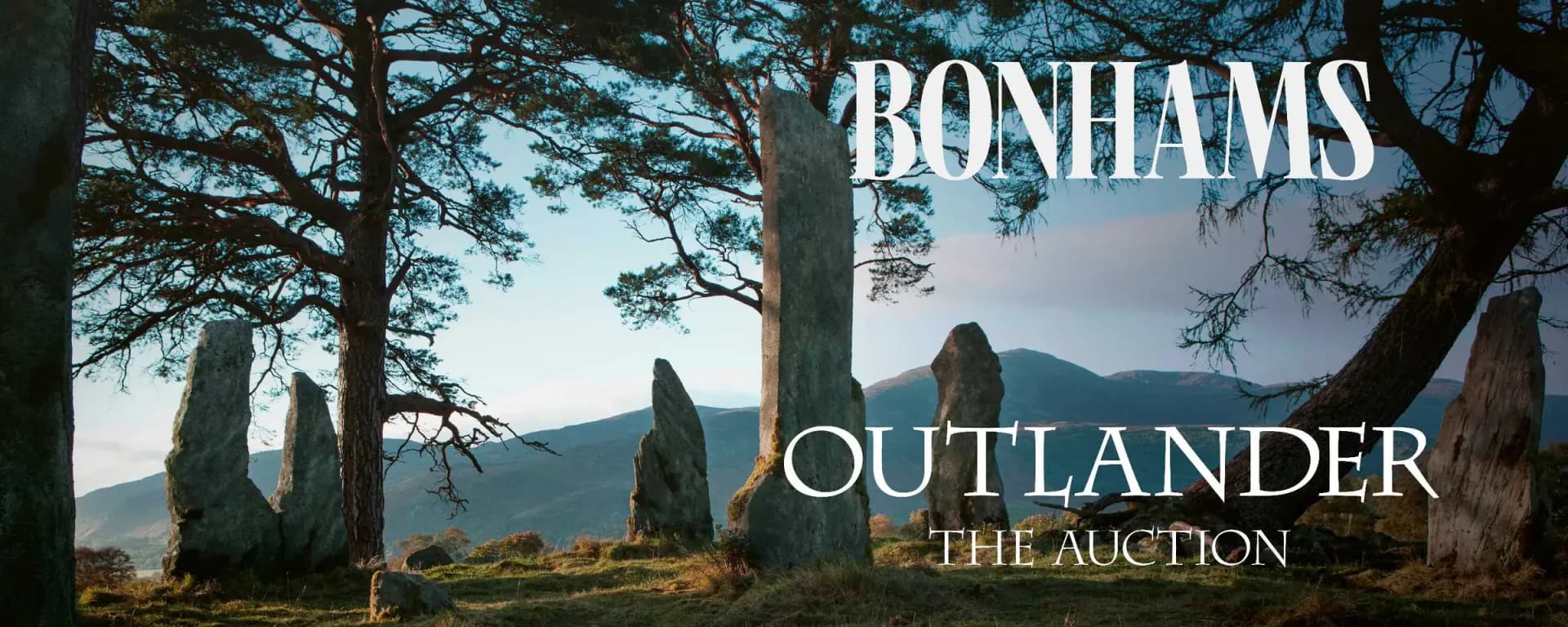 Bonhams 'Outlander: The Auction' promotional graphic with text overlay on standing stones and mountain scenery.