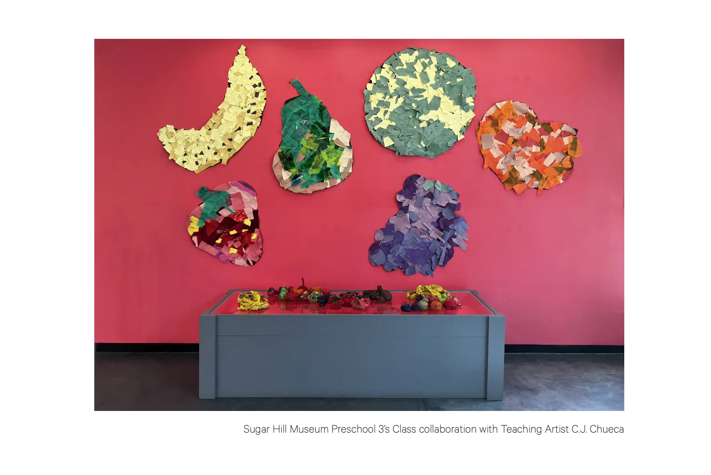 Six colorful sculptural forms with speckled paint texture suspended above a gray bin against a bright pink wall, Sugar Hill Museum Preschool class collaboration.