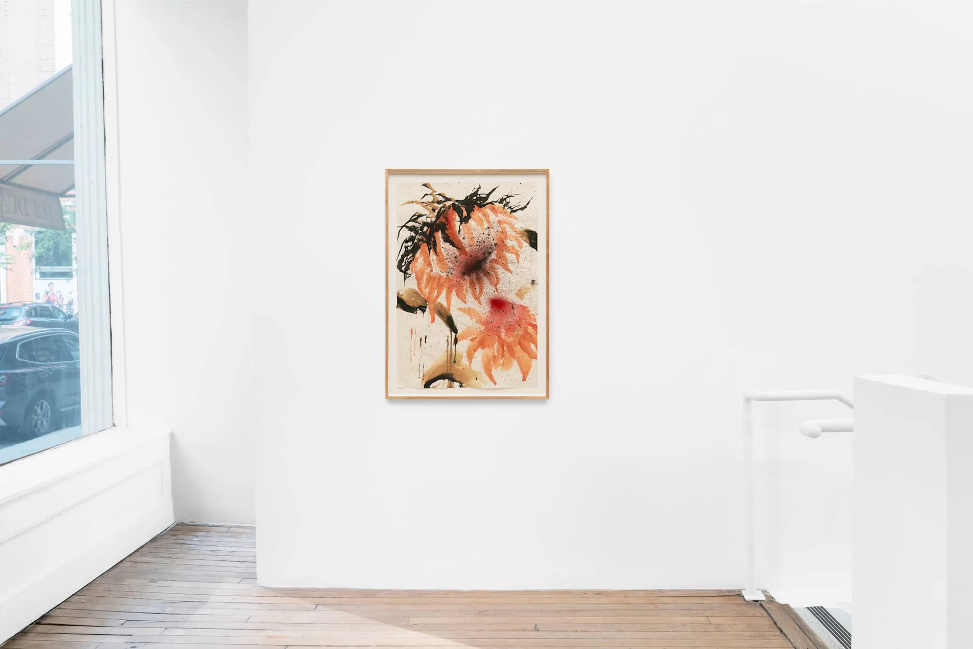 Corner of BUREAU gallery showing white walls, wooden floor, large window, and a single framed floral artwork on the wall.