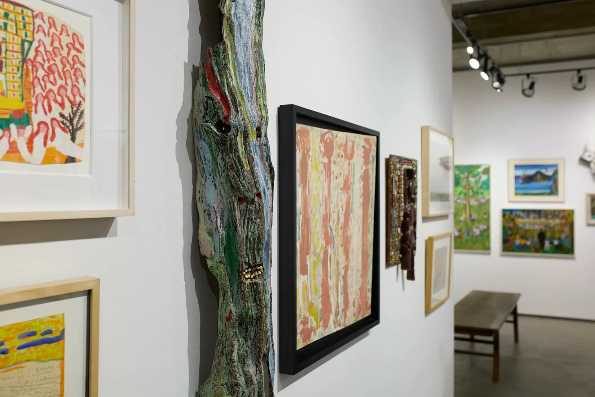 Cavin-Morris Gallery interior showing framed paintings and drawings on walls alongside sculptural pieces and mixed-media works in a contemporary exhibition layout.