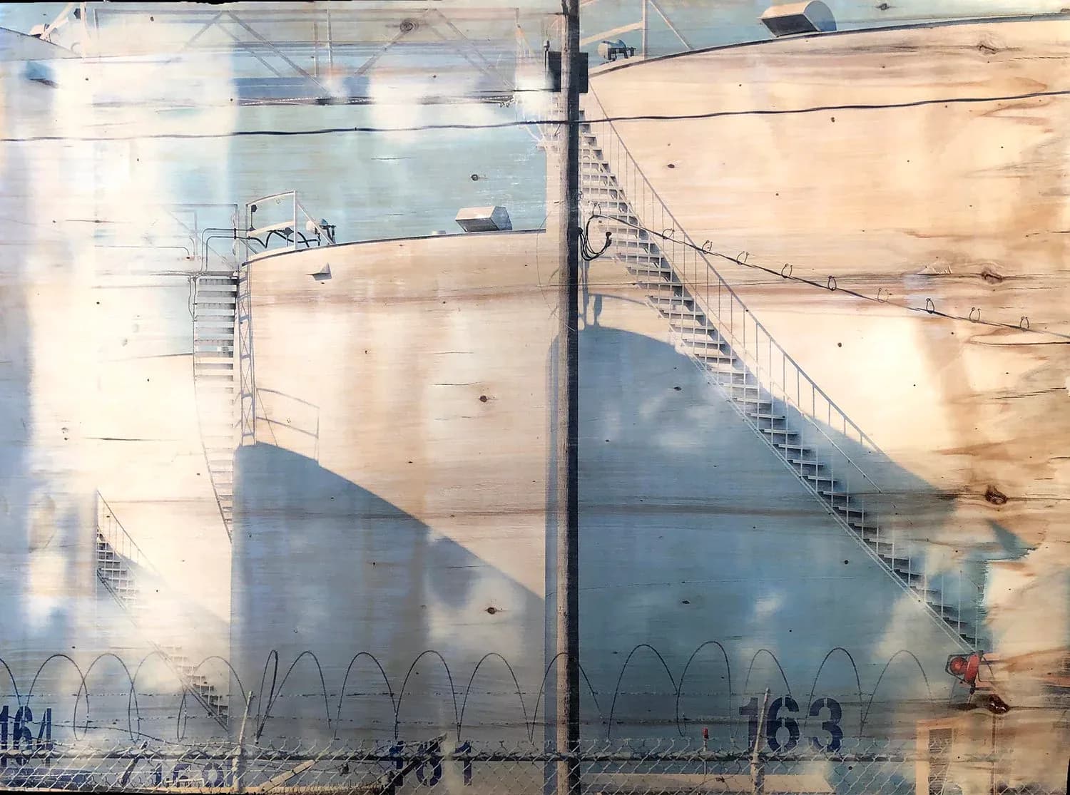 Photograph capturing reflections and shadows of stairs and barriers on a large institutional wall surface.