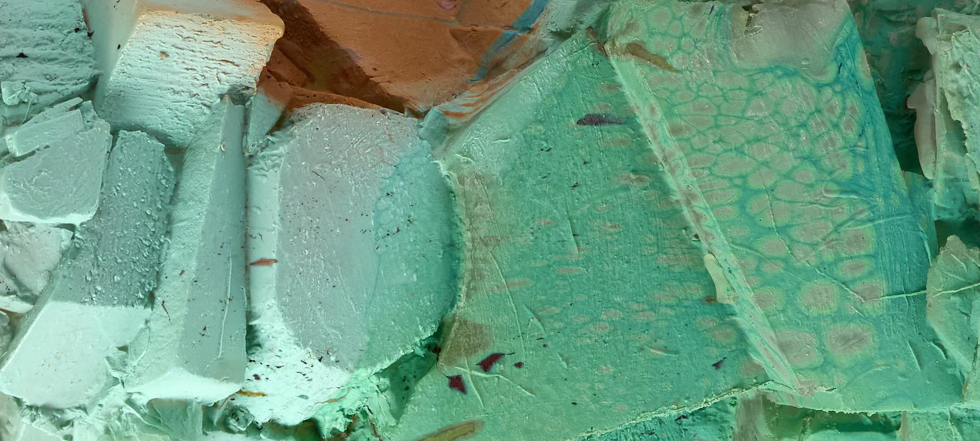 Turquoise and green painted sculptural fragments or architectural elements arranged on a floor.